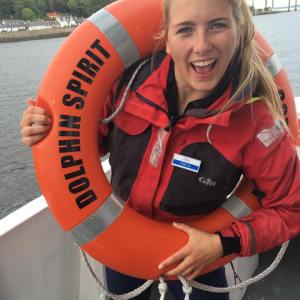 a person standing next to a body of water posing for the camera