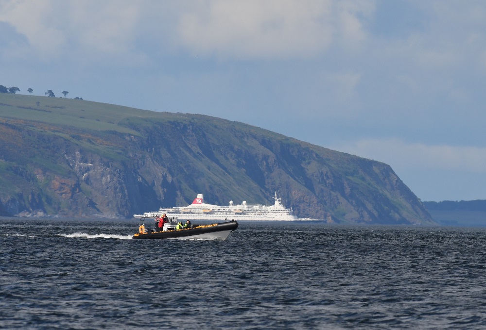 57 a small boat in a body of water with a mountain in the background
